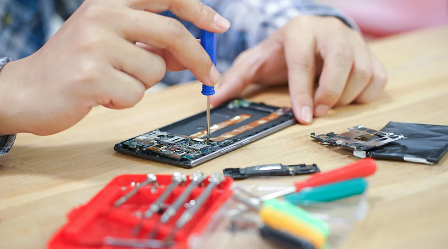 Technician repairing smartphone with professional tools